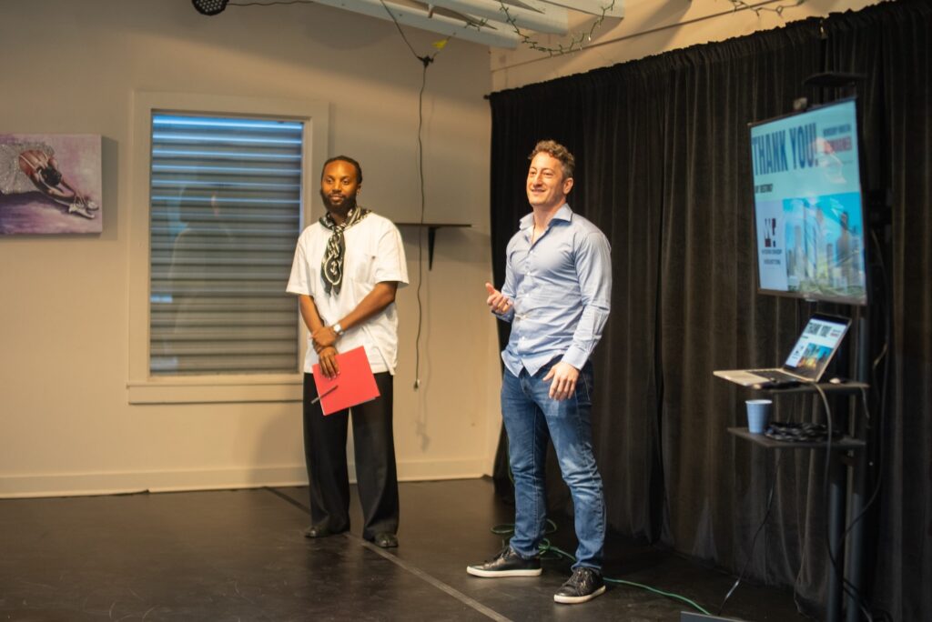 Lance presenting with man during final round of Impact Competiton