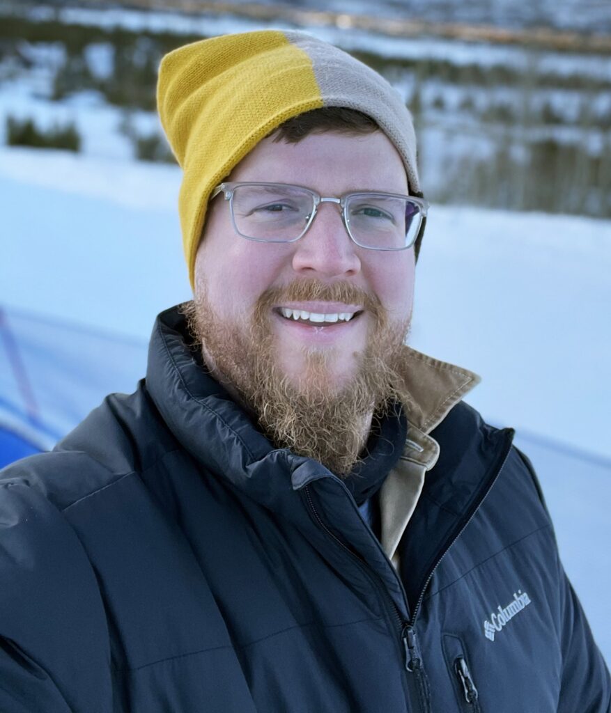 George Belcher headshot smiling outside wearing jacket